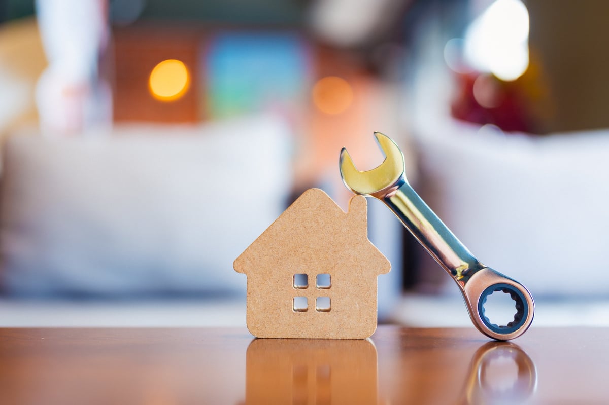 House model with a wrench symbolizing home maintenance, repair and improvement